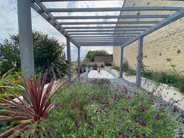 outdoor space in french holiday gite with table and chairs and metal pergola
