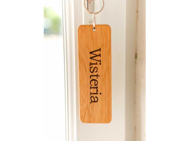 close up of door with hanging key fob reading 'Wisteria'