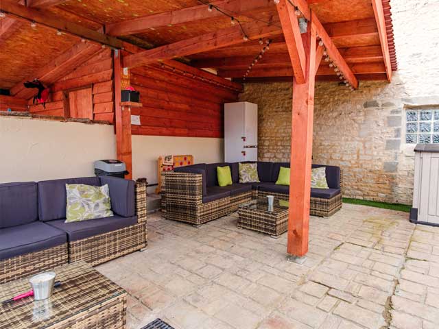 shadey outdoor seating area with comfortable wicker chairs and cushions