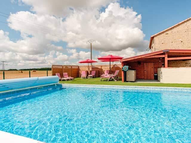 blue water of swimming pool with chairs and parasols on the other side