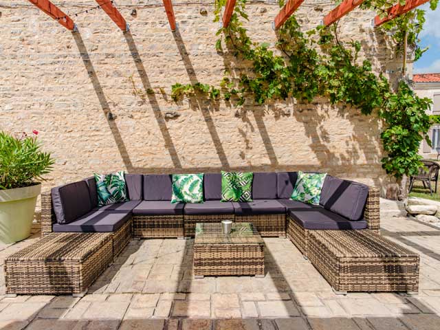 summer seating area with large garden pot plants