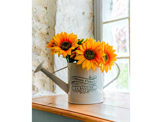 windowsill with metal jug and sunflowers