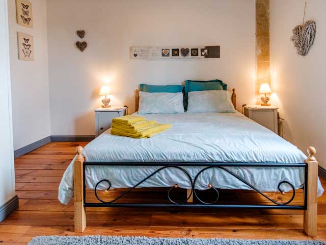 double bedroom with wooden floors, white walls and heart-shaped fixtures