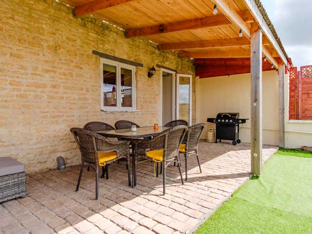 shadey courtyard area with patio furniture and bbq